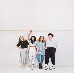 four women laughing together in stylish outfts wearing Noz sunscreen