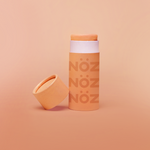 Load image into Gallery viewer, Orange Noz sunscreen standing with cap leaning on container
