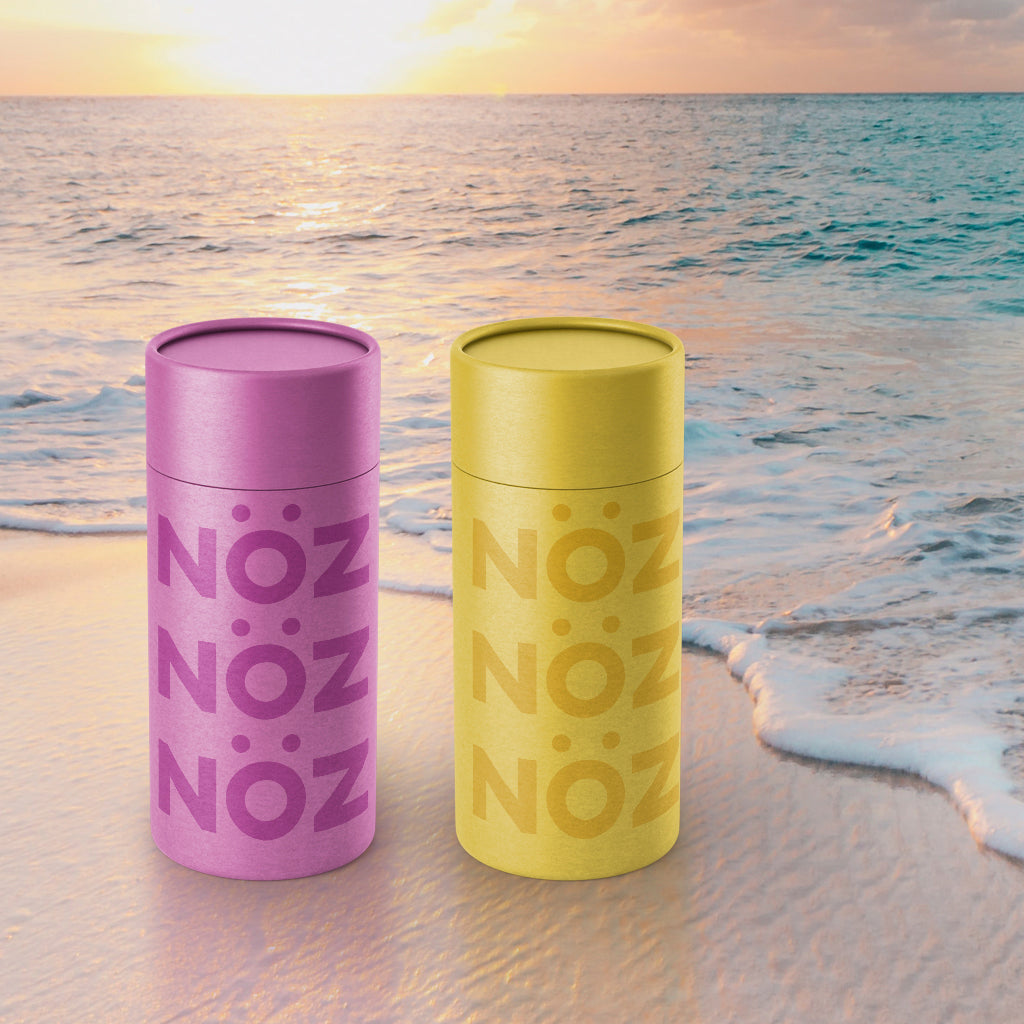 Purple and yellow Noz sunscreen on the  beach